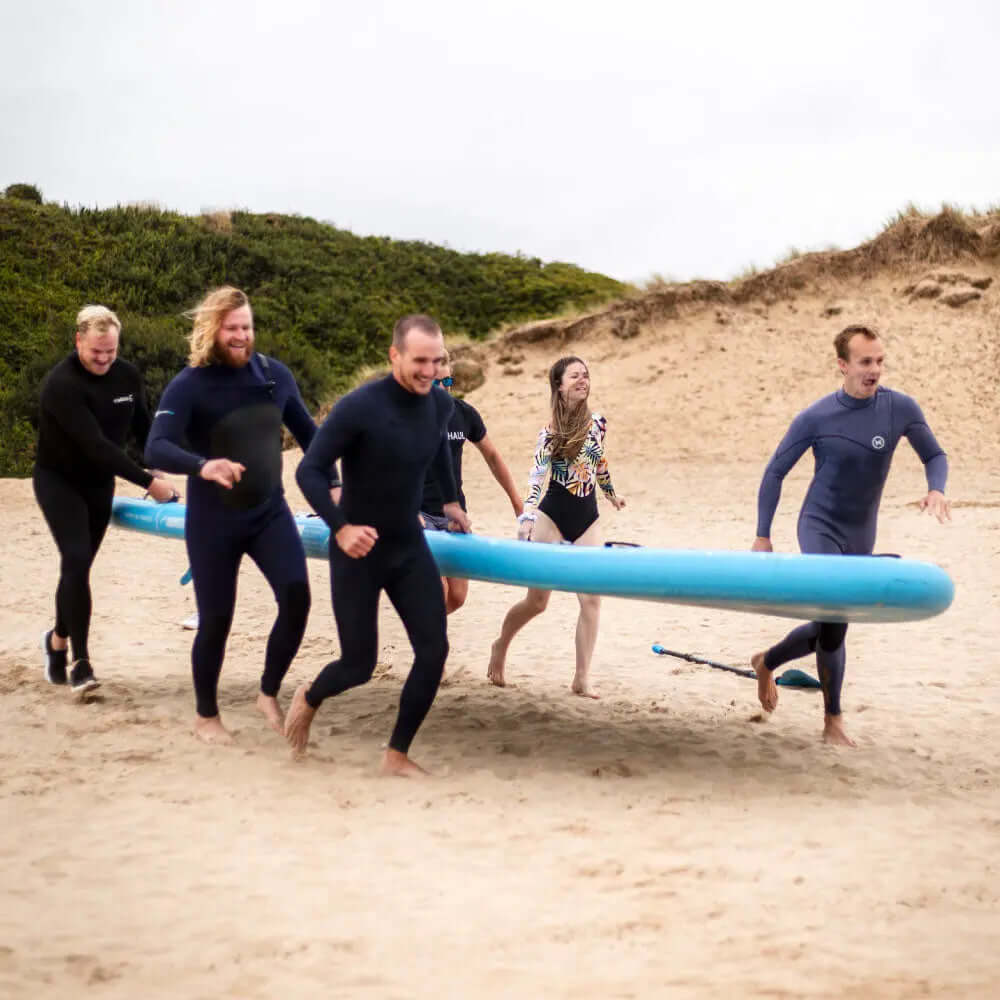 Groep draagt de Mammoth paddleboard op het strand